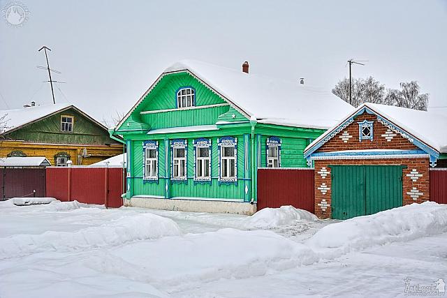 Green Wooden House with Garage on Pushkarskaya Street in Wintert