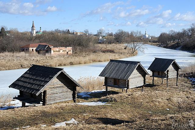 Three old barns on stilts near frozen Kamenka river