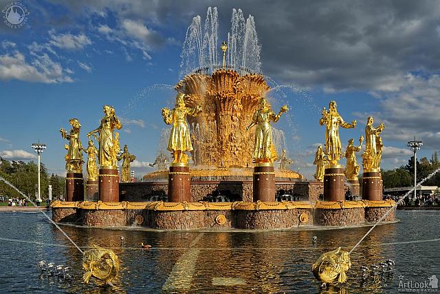 Shining Gold Friendship of Nations Fountain Against Grey Clouds