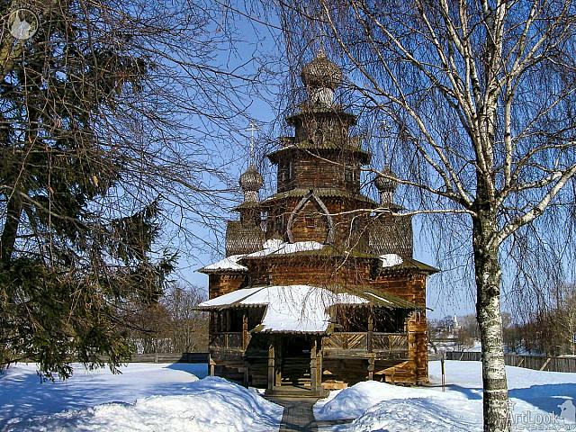Wooden Transfiguration Church behind Trees in Snow