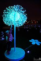 A Kid Touching a Neon Dandelion in Tsaritsyno Park